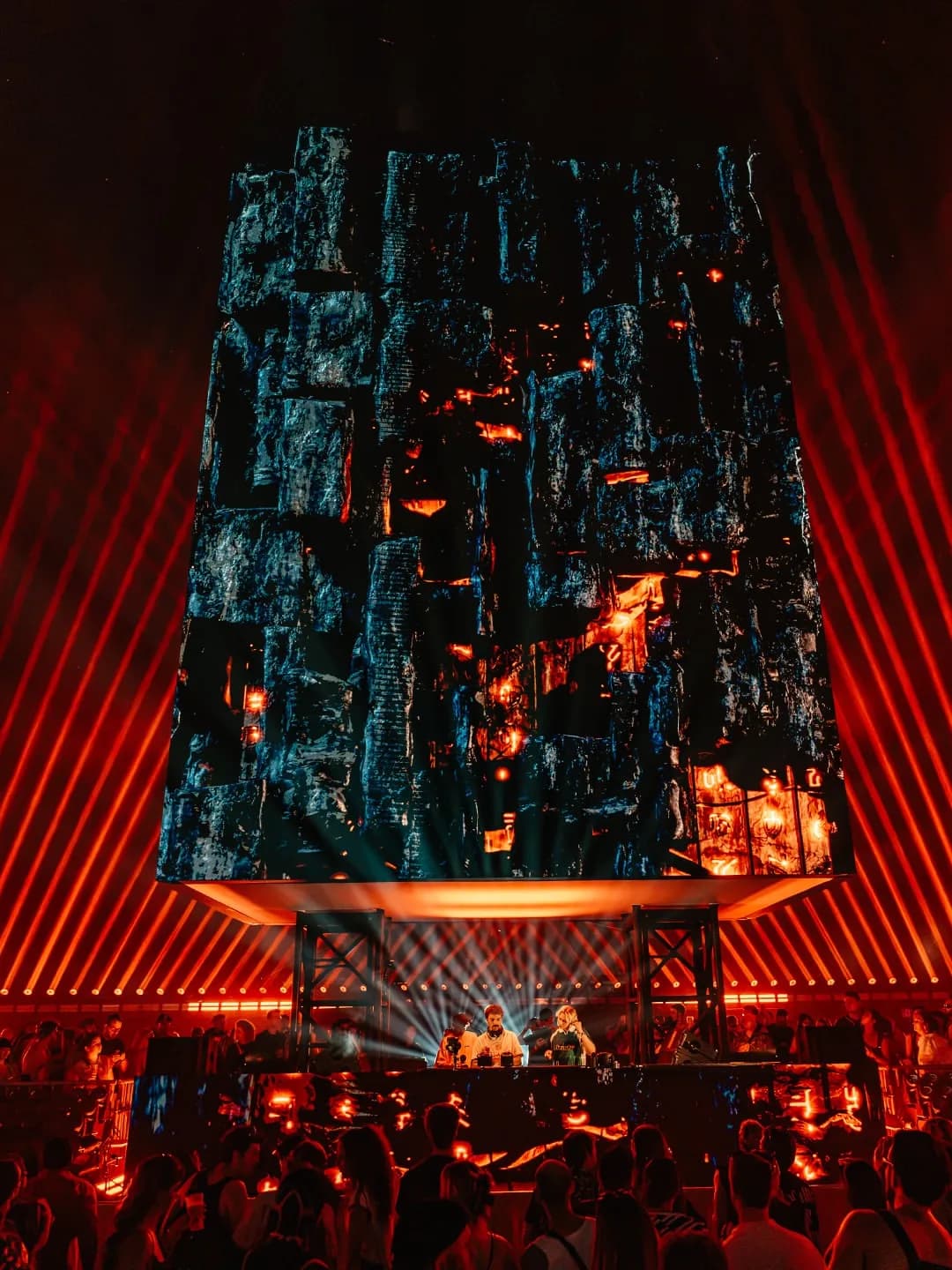 A towering stage structure glowing red above the crowd